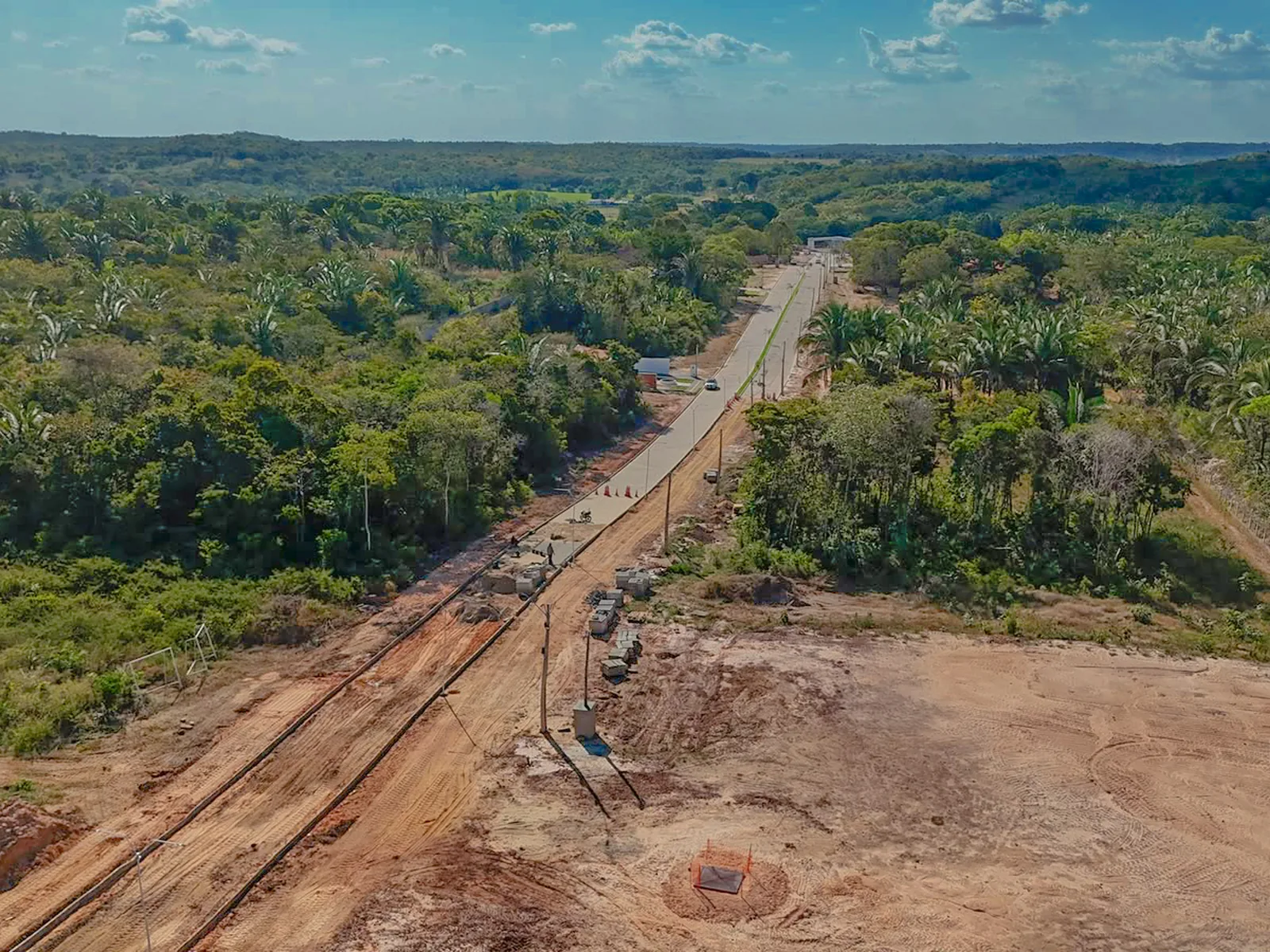 Vista aérea da terraplenagem e da via principal do Reserva do Longá em meio à mata