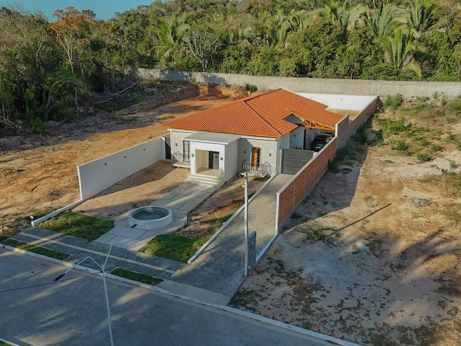 Casa concluída em lote da 1ª etapa, com muro, calçada e rua pavimentada